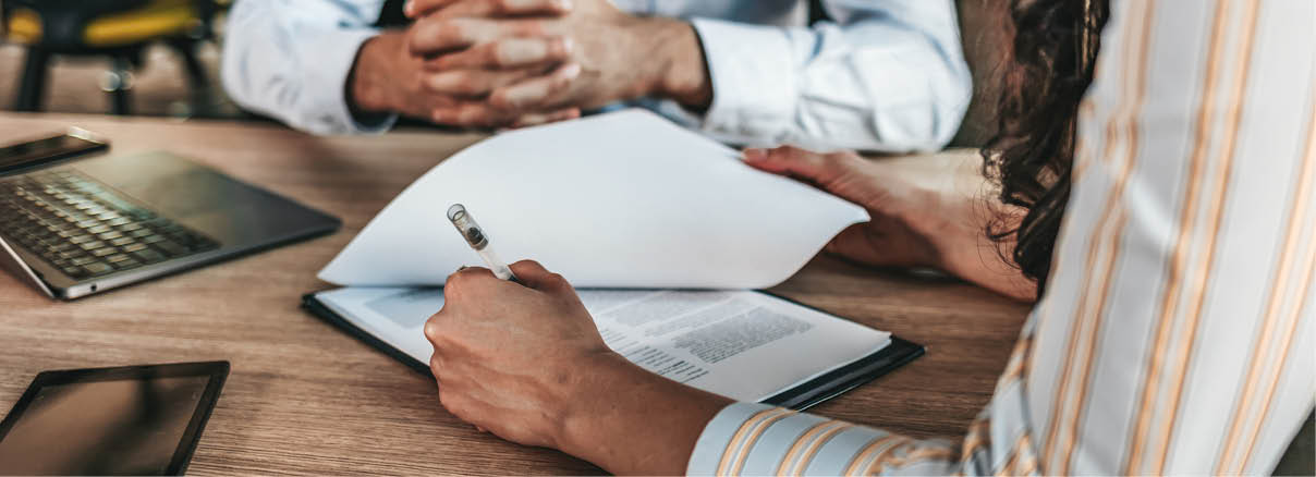 Female businessperson signs contract  Close up of female hand signing formal paper on the office table