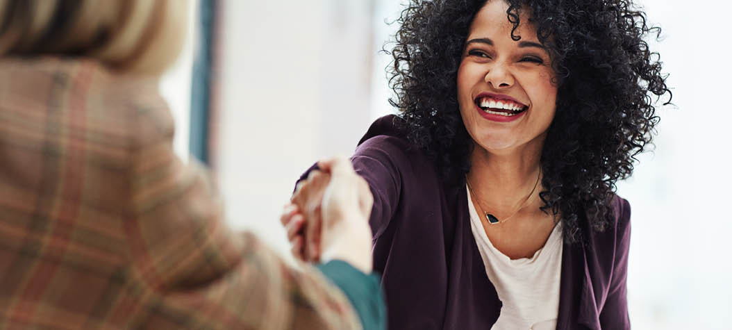 Shot of two colleagues shaking hands during a meeting at work